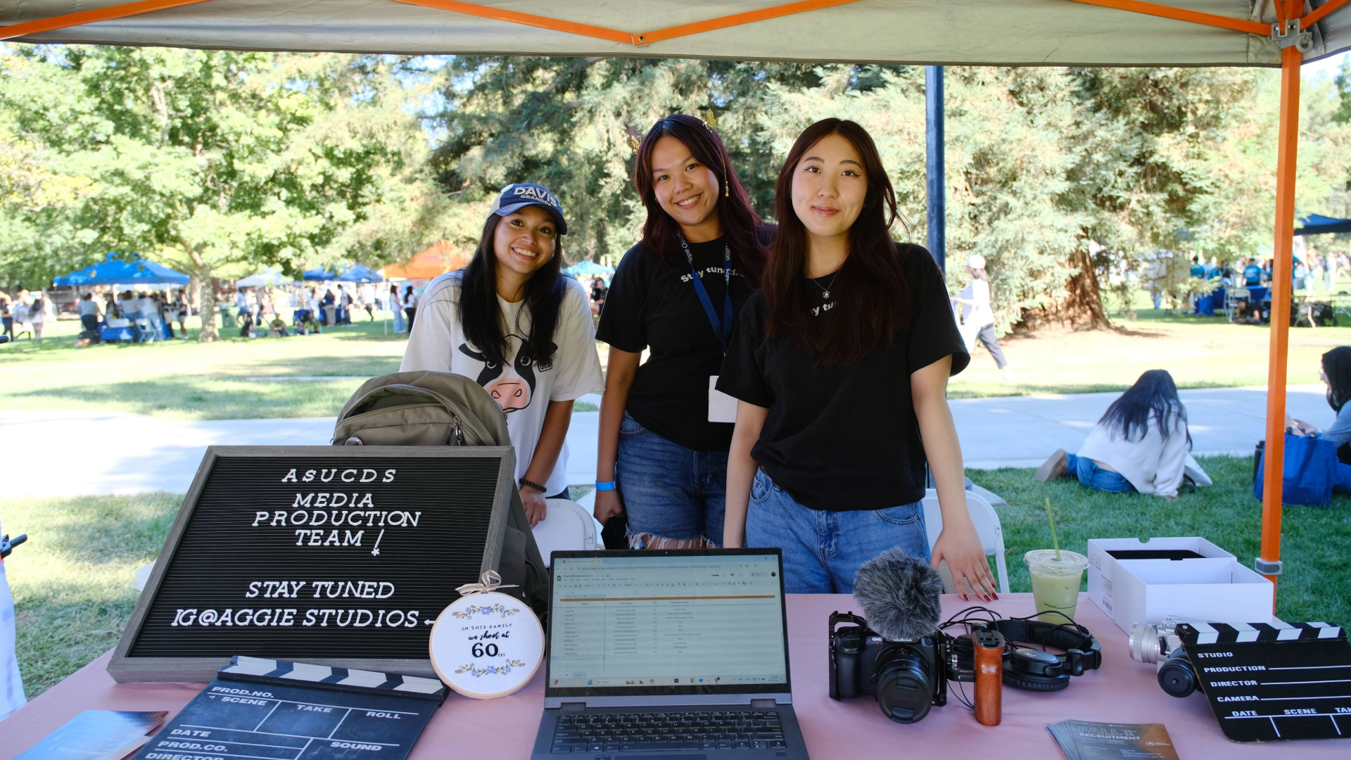 Three Studio members pose for the camera while tabling at Davisfest