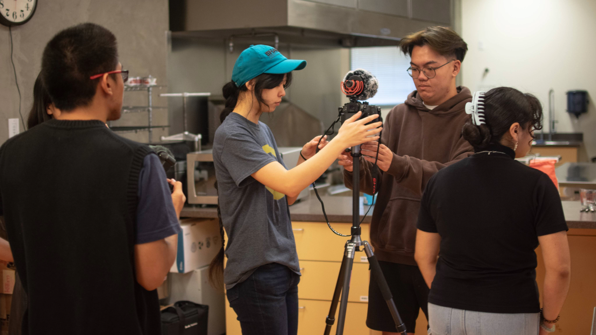 Videographers set up a camera inside a kitchen